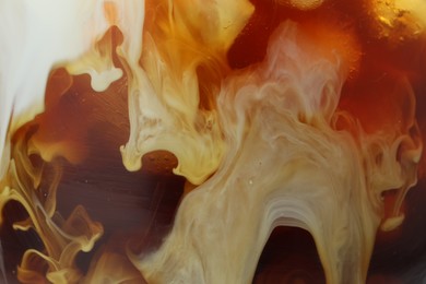 Photo of Refreshing coffee with ice and milk as background, closeup