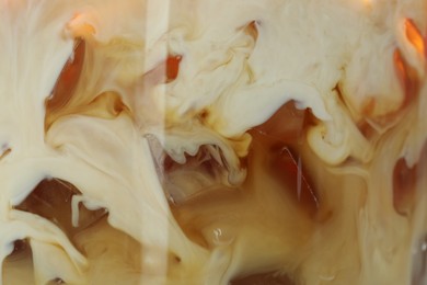 Photo of Refreshing coffee with ice and milk as background, closeup