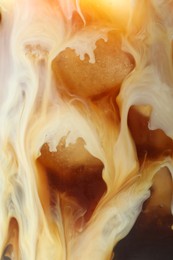 Photo of Refreshing coffee with ice and milk as background, closeup