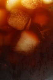 Photo of Refreshing coffee with ice cubes as background, closeup