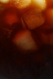 Photo of Refreshing coffee with ice cubes as background, closeup