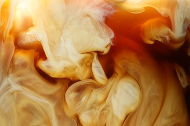 Photo of Refreshing coffee with ice and milk as background, closeup