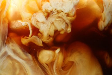 Photo of Refreshing coffee with ice and milk as background, closeup