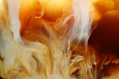 Photo of Refreshing coffee with ice and milk as background, closeup