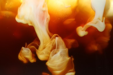 Photo of Refreshing coffee with ice and milk as background, closeup