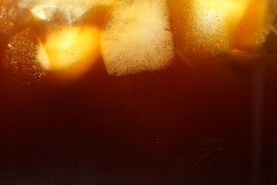 Photo of Refreshing coffee with ice cubes as background, closeup