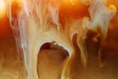 Photo of Refreshing coffee with ice and milk as background, closeup