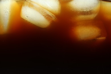 Photo of Refreshing coffee with ice cubes as background, closeup