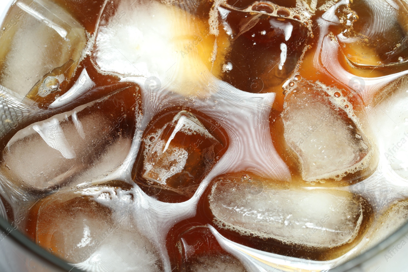 Photo of Refreshing coffee with ice and milk in glass, top view