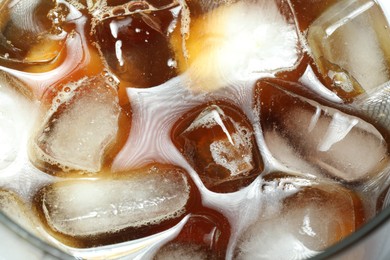 Photo of Refreshing coffee with ice and milk in glass, top view