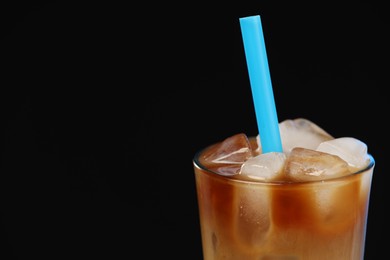 Photo of Refreshing iced coffee with milk in glass on black background, closeup. Space for text