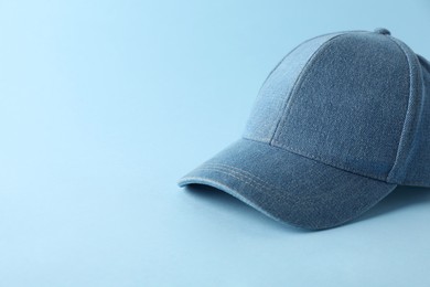 Photo of Stylish denim baseball cap on light blue background. Mockup for design