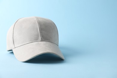 Photo of Stylish baseball cap on light blue background. Mockup for design