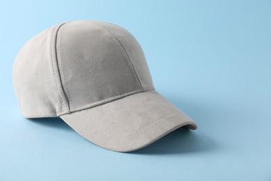 Photo of Stylish baseball cap on light blue background. Mockup for design