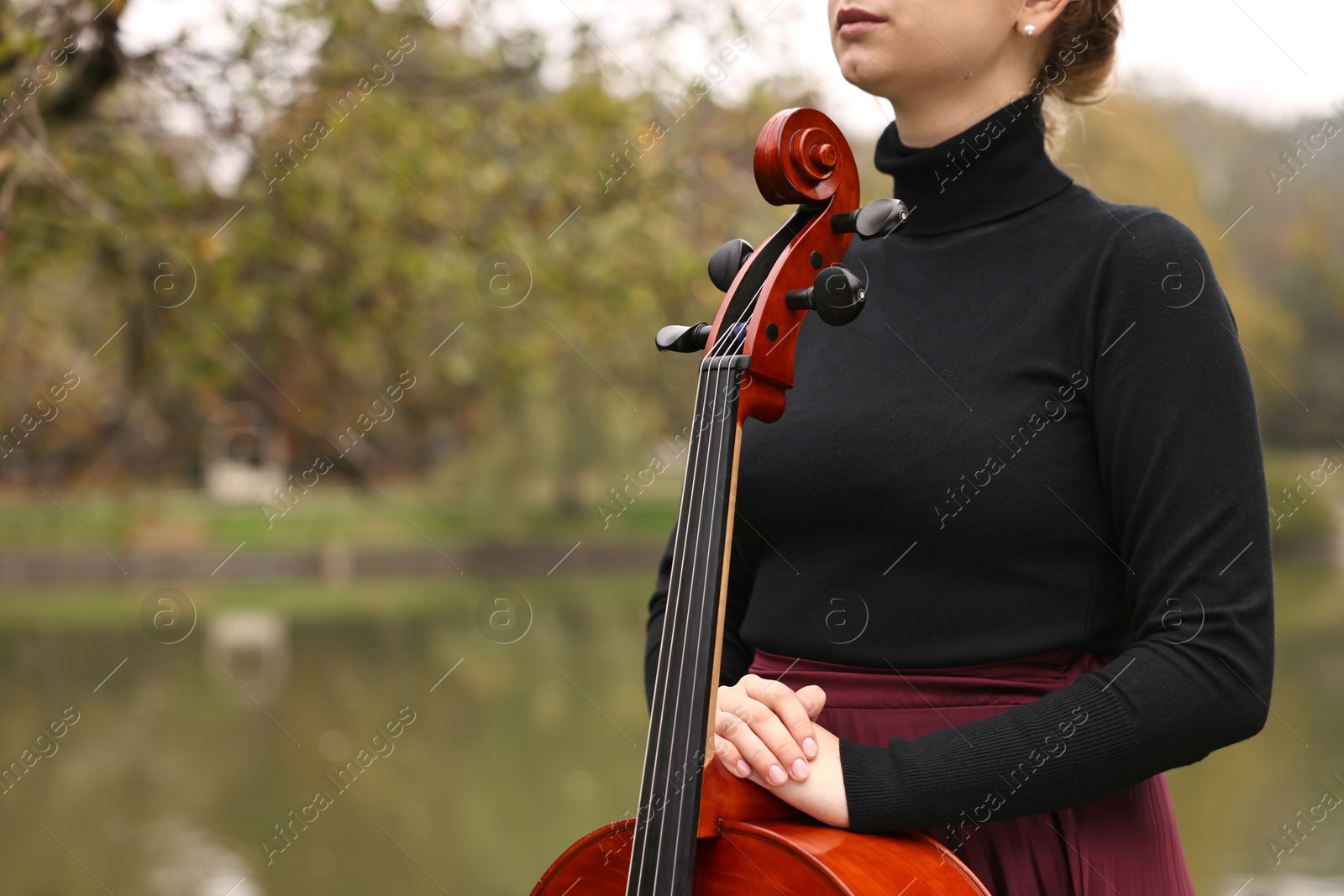 Photo of Young woman with cello in park, closeup. Space for text