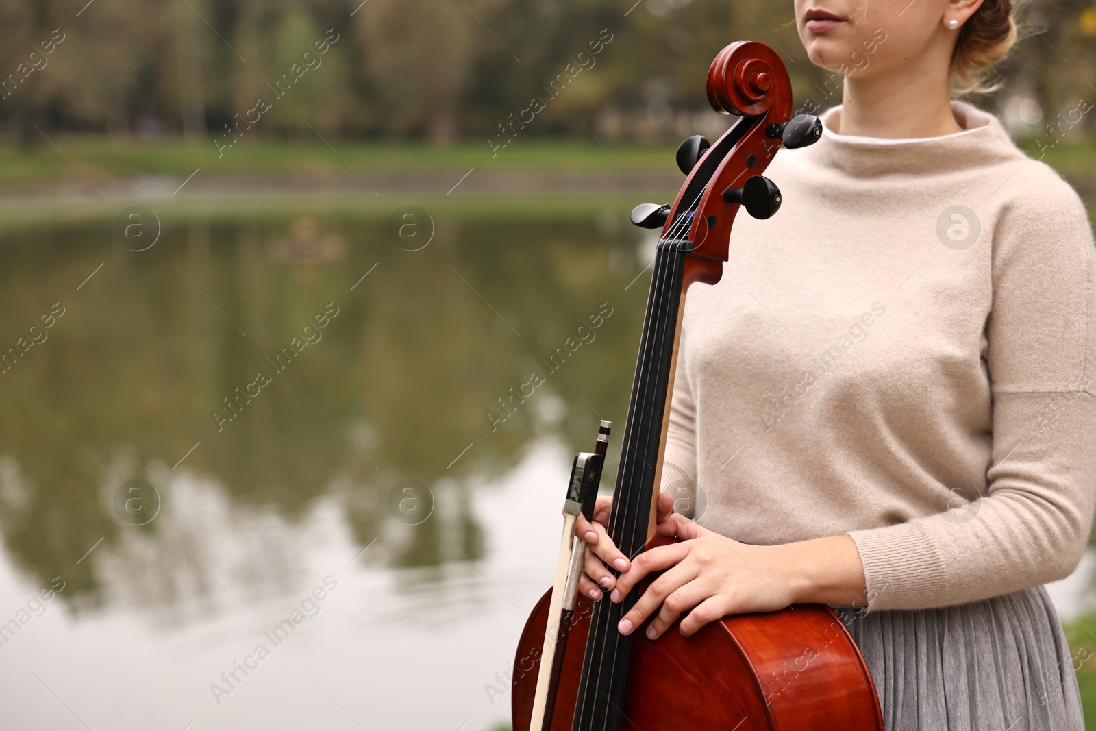 Photo of Young woman with cello in park, closeup. Space for text