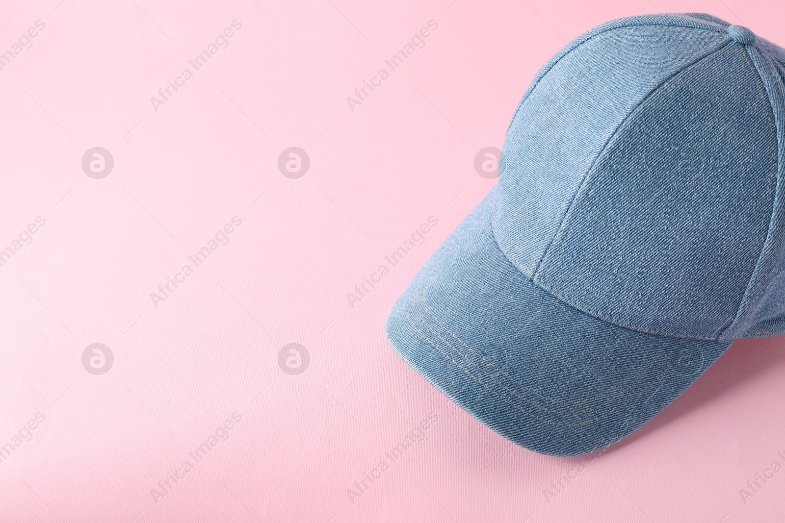 Photo of Stylish denim baseball cap on pink background. Mockup for design