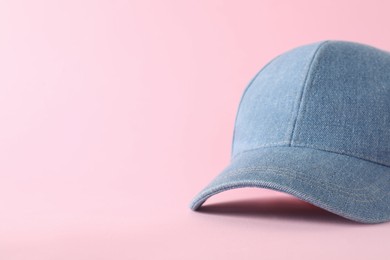 Photo of Stylish denim baseball cap on pink background, closeup. Mockup for design