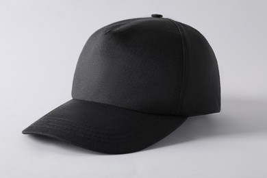 Photo of Stylish black baseball cap on light grey background, closeup. Mockup for design