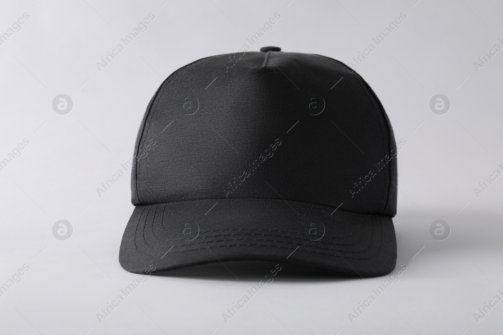 Photo of Stylish black baseball cap on light grey background, closeup. Mockup for design