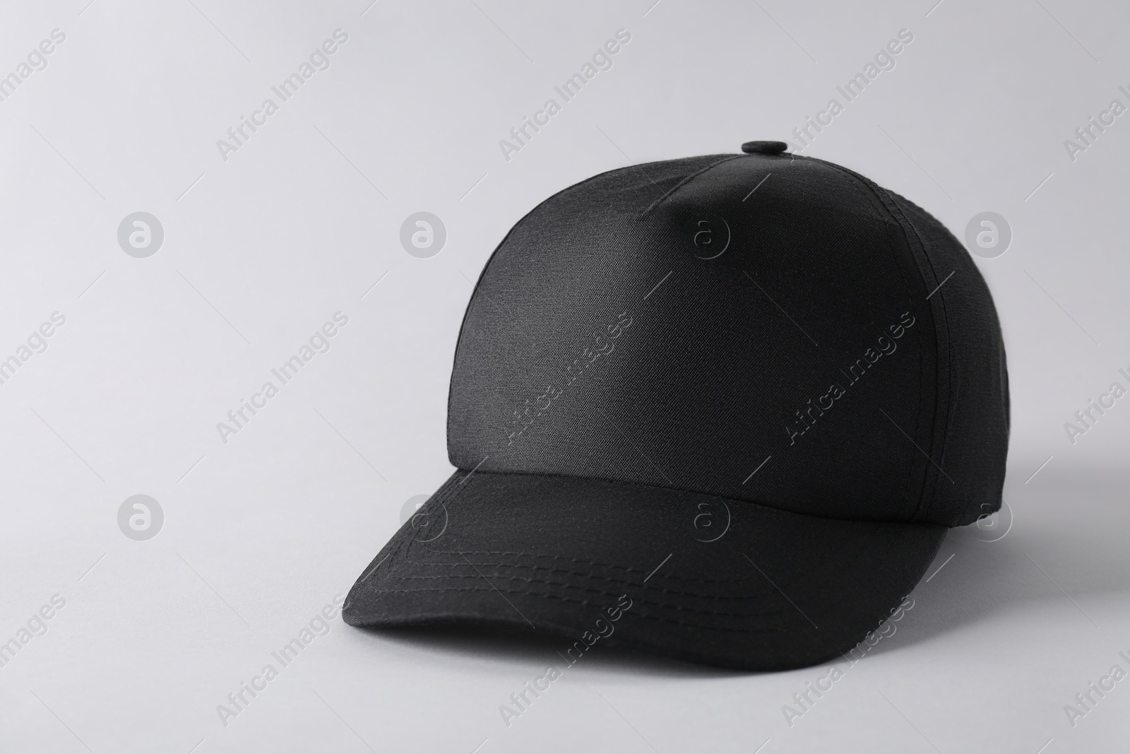 Photo of Stylish black baseball cap on light grey background. Mockup for design