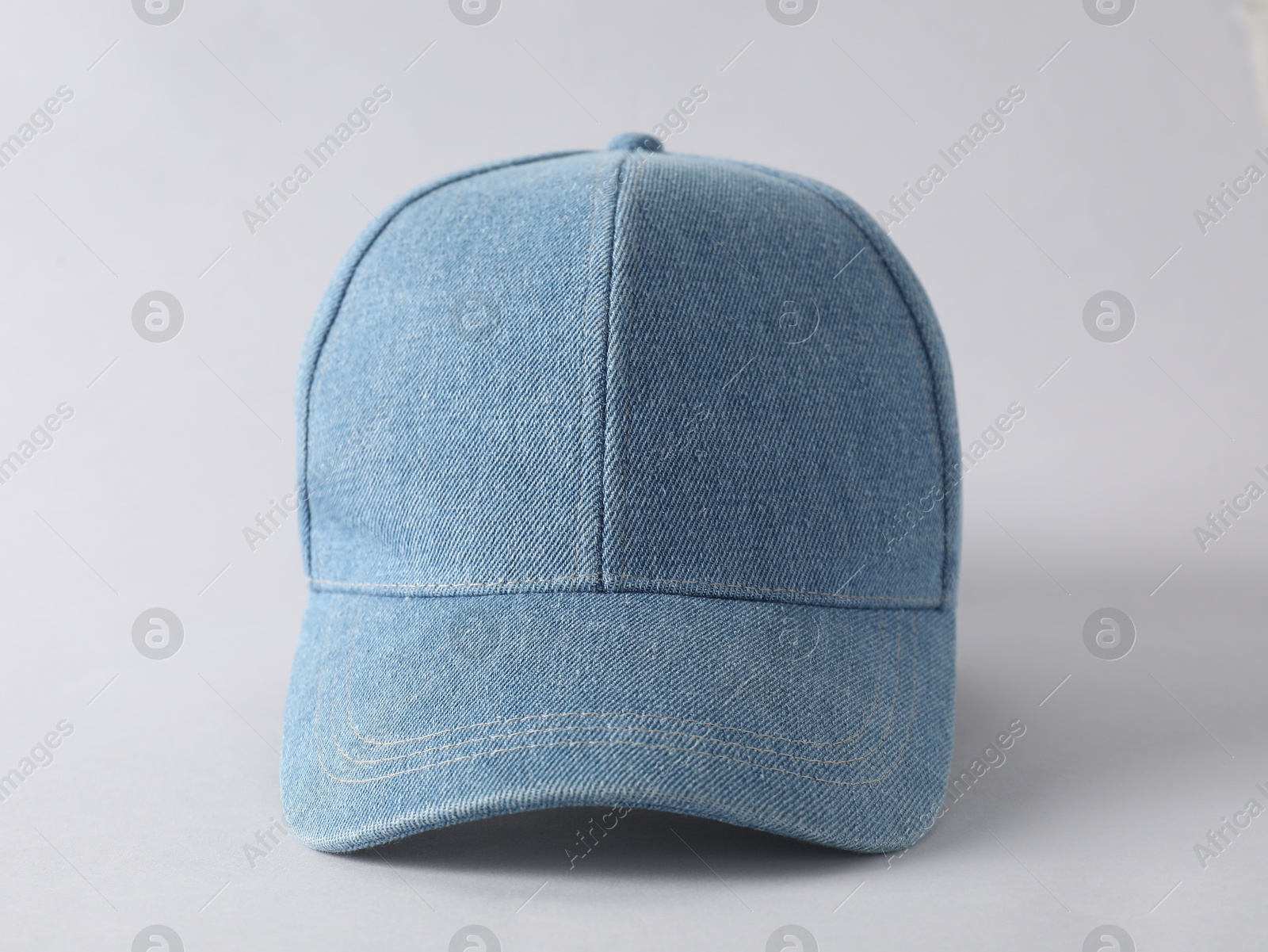 Photo of Stylish denim baseball cap on light grey background, closeup. Mockup for design