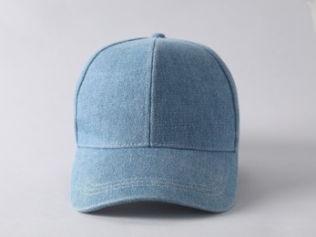 Photo of Stylish denim baseball cap on light grey background, closeup. Mockup for design