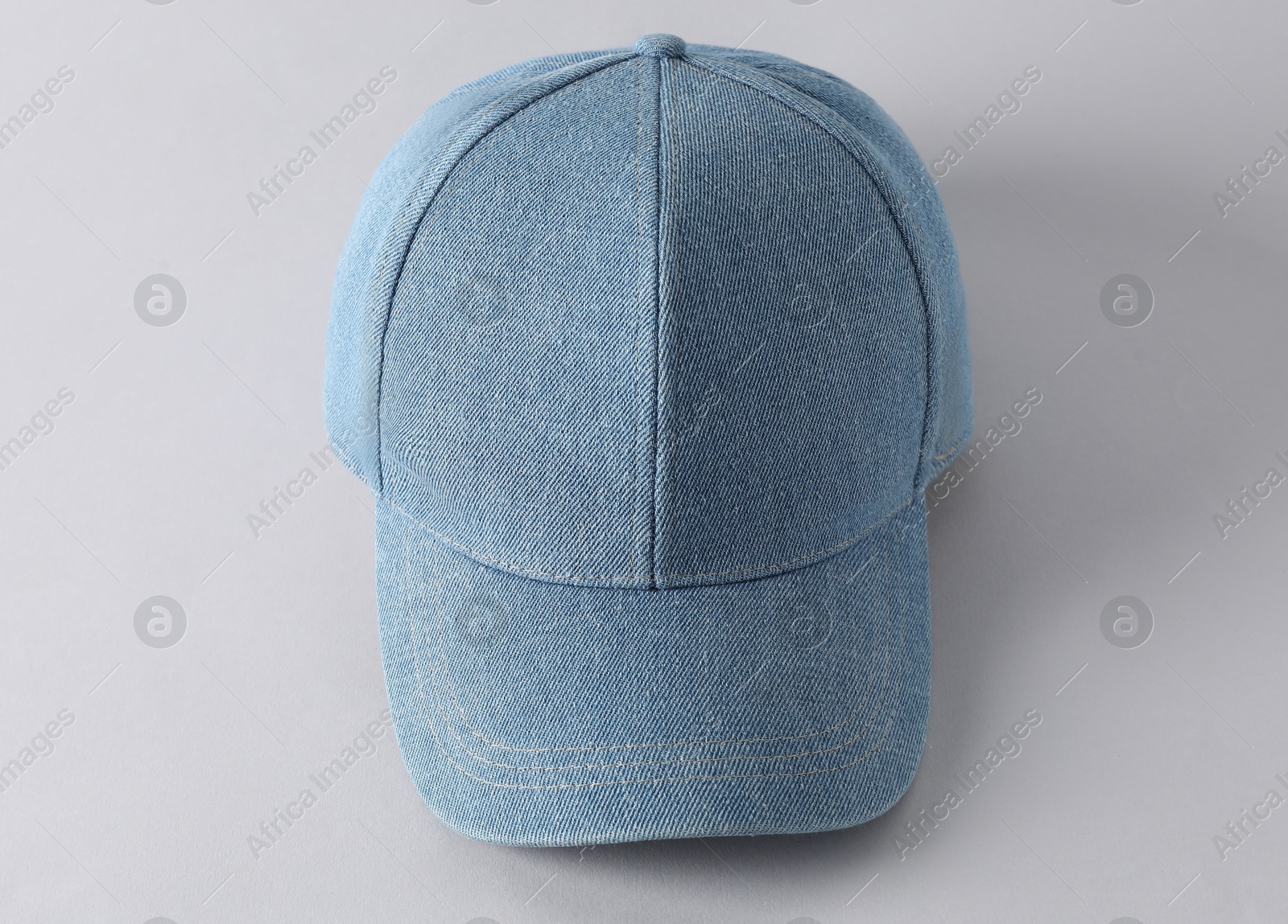 Photo of Stylish denim baseball cap on light grey background, above view. Mockup for design