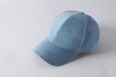 Photo of Stylish denim baseball cap on light grey background. Mockup for design