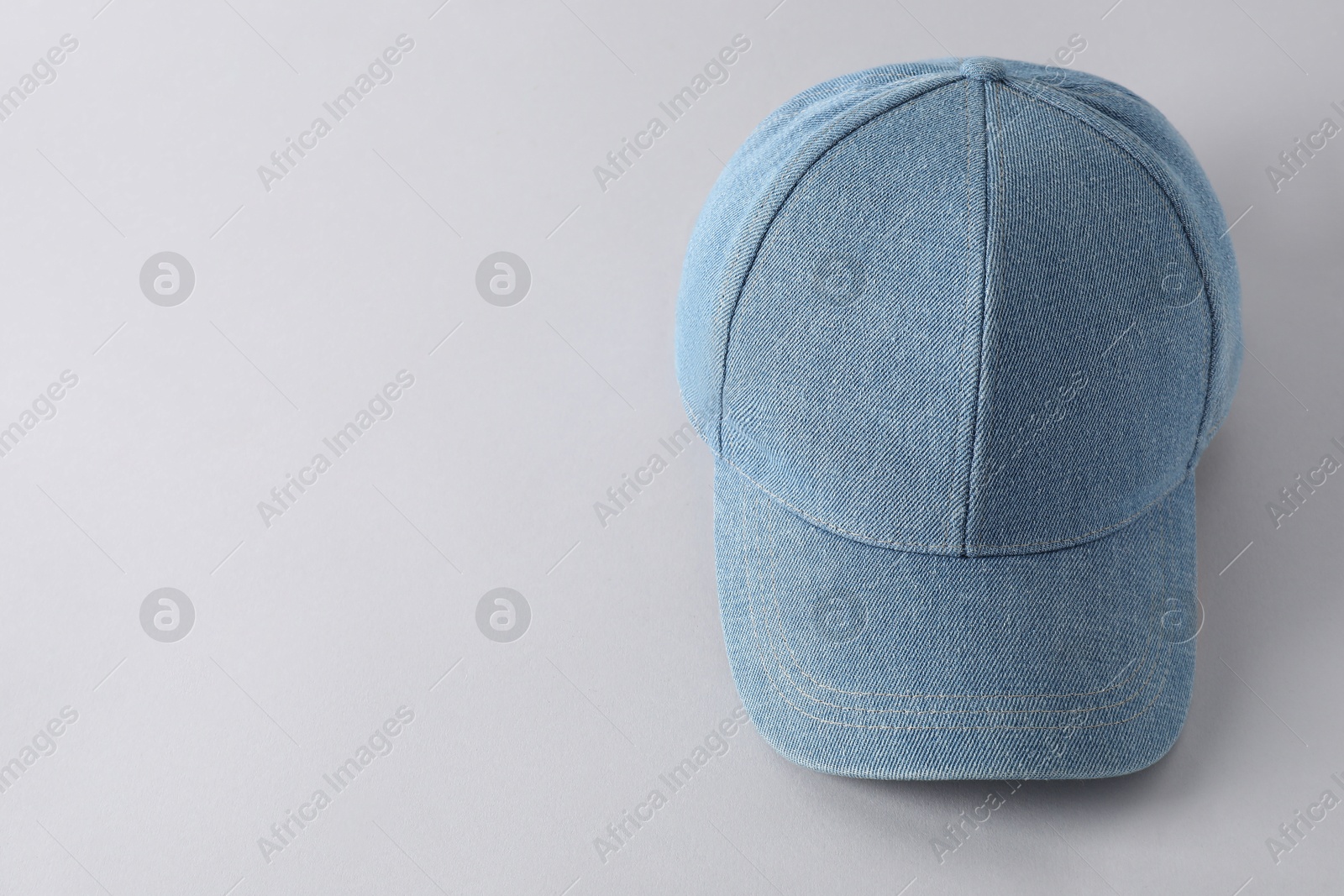 Photo of Stylish denim baseball cap on light grey background, above view. Mockup for design