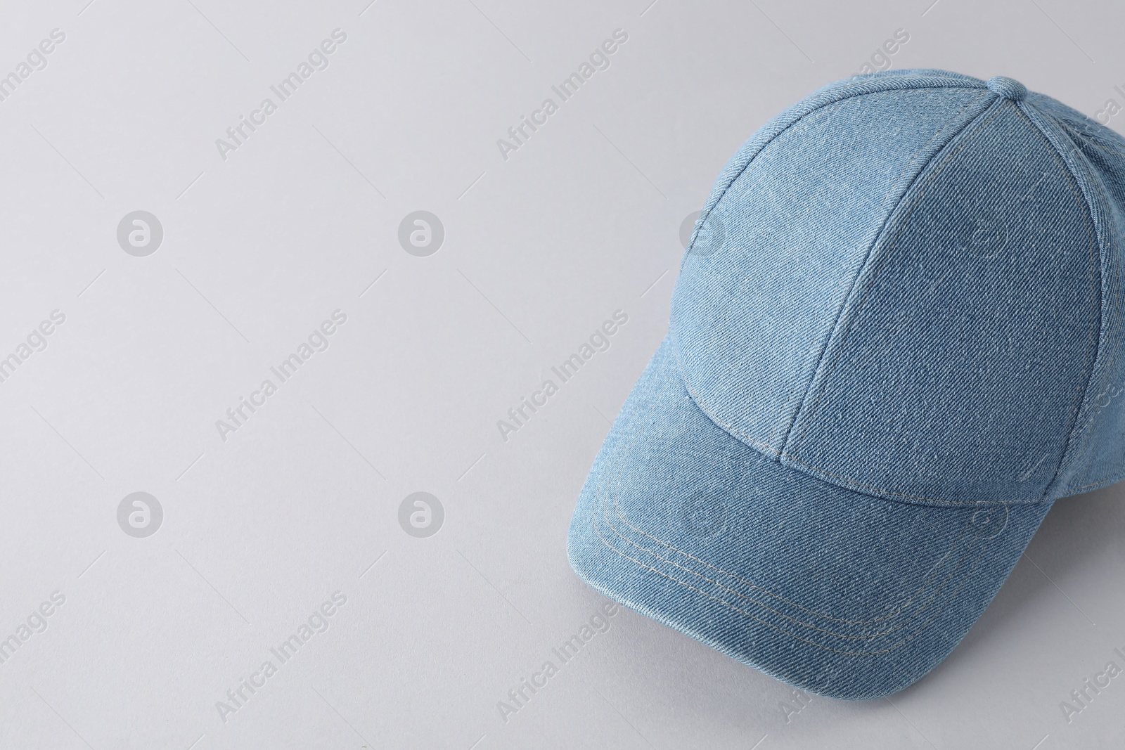 Photo of Stylish denim baseball cap on light grey background. Mockup for design