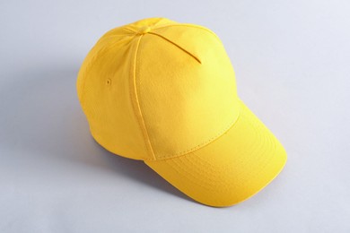 Photo of Stylish yellow baseball cap on light grey background. Mockup for design