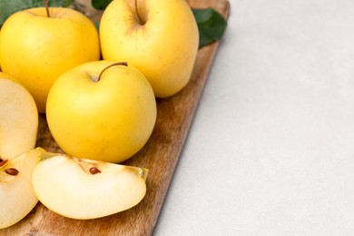 Ripe yellow apples on light grey table, closeup. Space for text