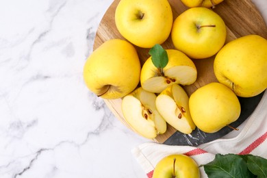 Photo of Ripe yellow apples on white marble table, top view. Space for text