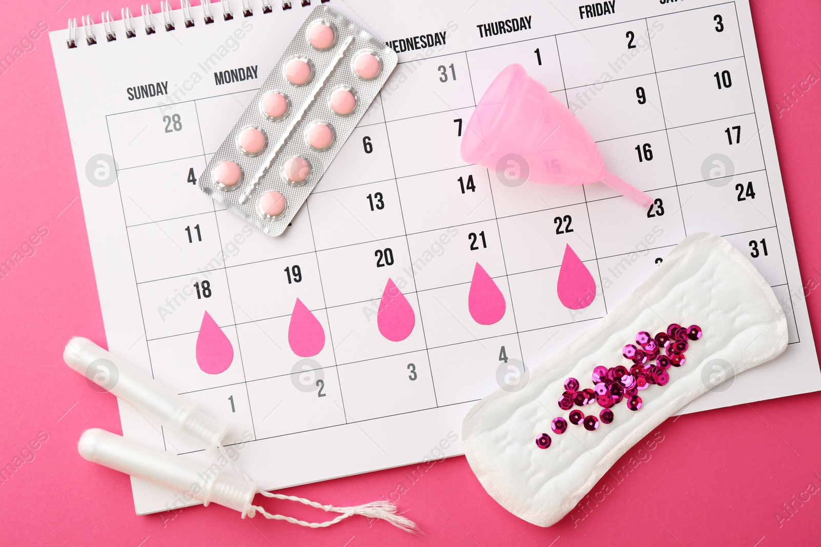 Photo of Calendar with marked dates, menstrual pad with sequins, cup, pills and tampons on pink background, top view