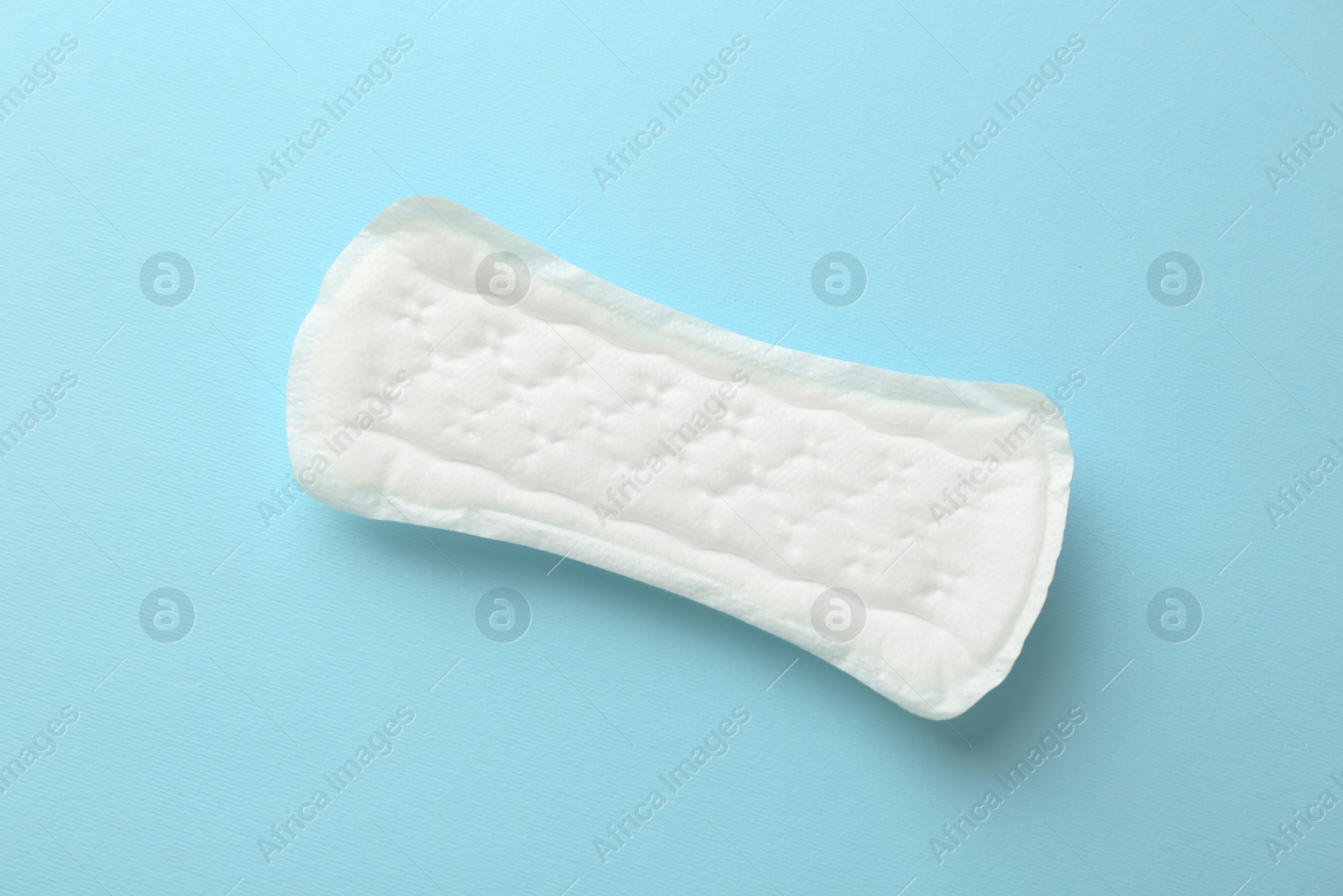 Photo of Menstrual pad on light blue background, top view