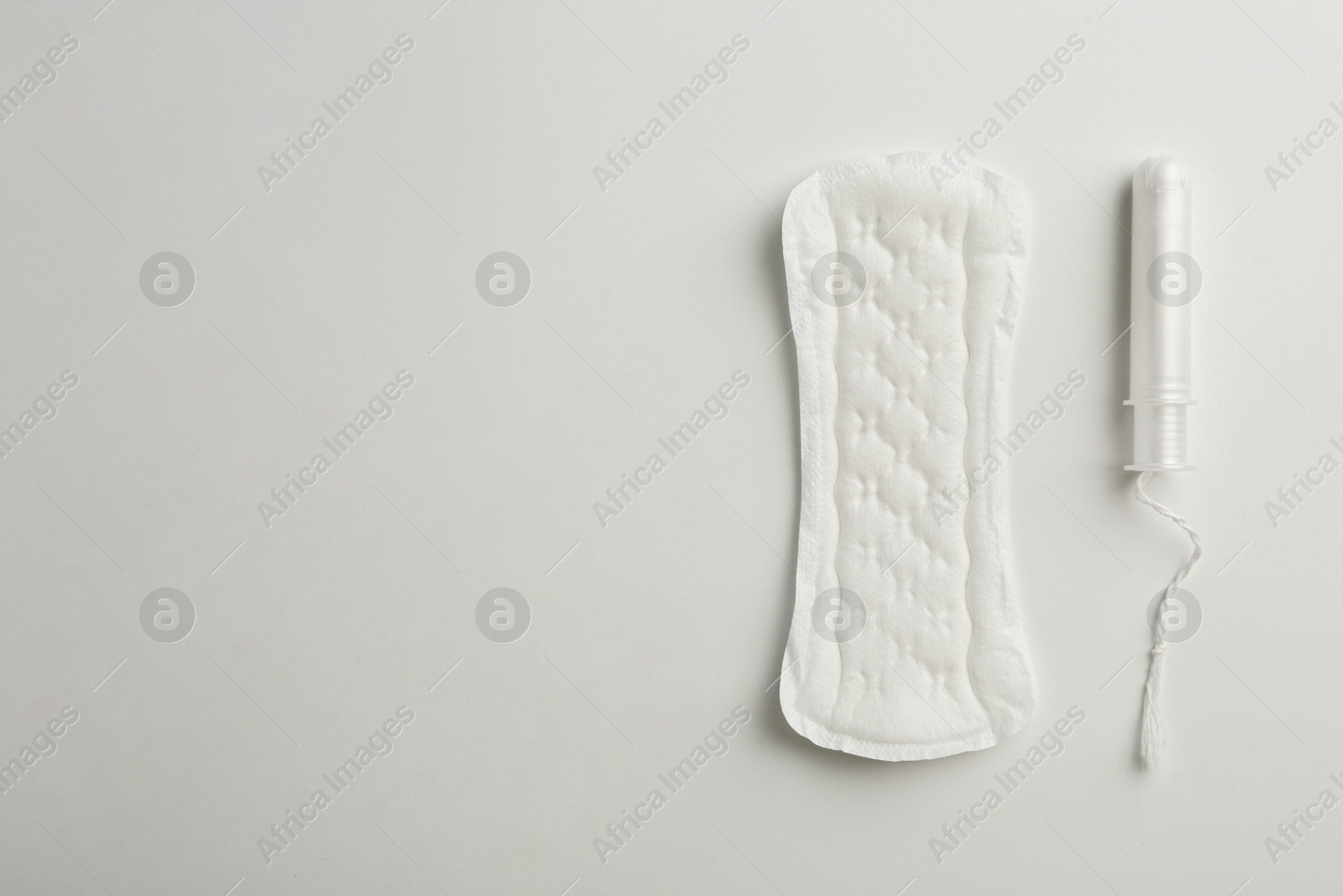 Photo of Menstrual pad and tampon on white background, top view. Space for text