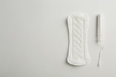 Photo of Menstrual pad and tampon on white background, top view. Space for text