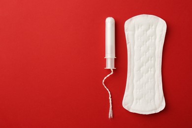 Photo of Menstrual pad and tampon on red background, top view. Space for text