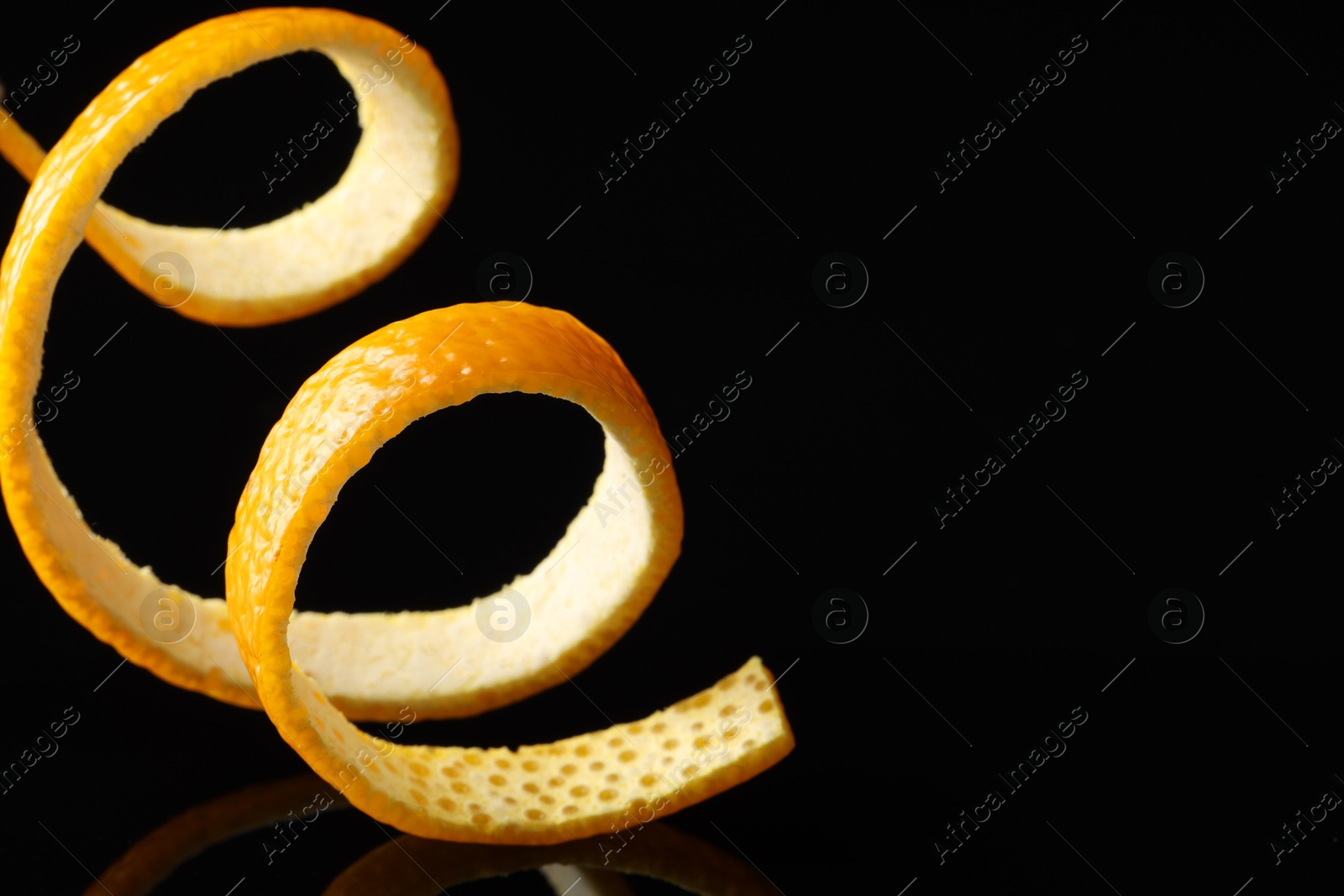 Photo of One fresh orange peel on black background, closeup. Space for text