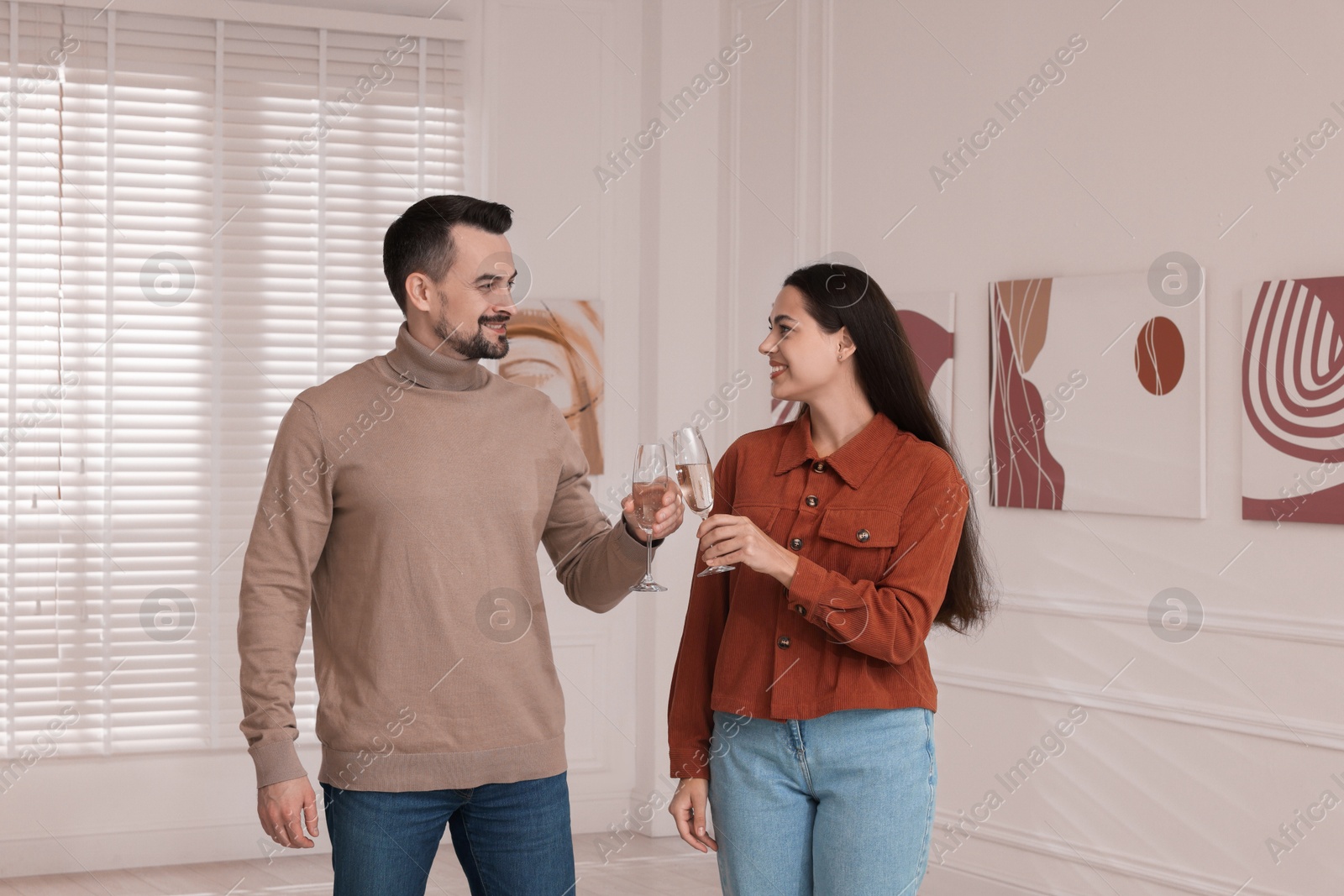 Photo of Couple enjoying art and sparkling wine in gallery