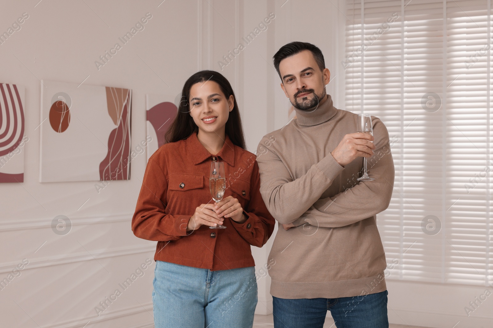 Photo of Couple enjoying art and sparkling wine in gallery