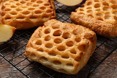 Photo of Delicious puff pastries with fruit filling on wooden table, closeup