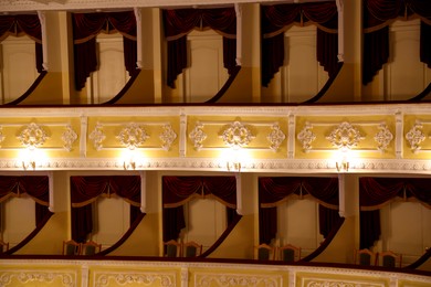 Photo of Balconies with comfortable chairs and vintage lamps in theatre