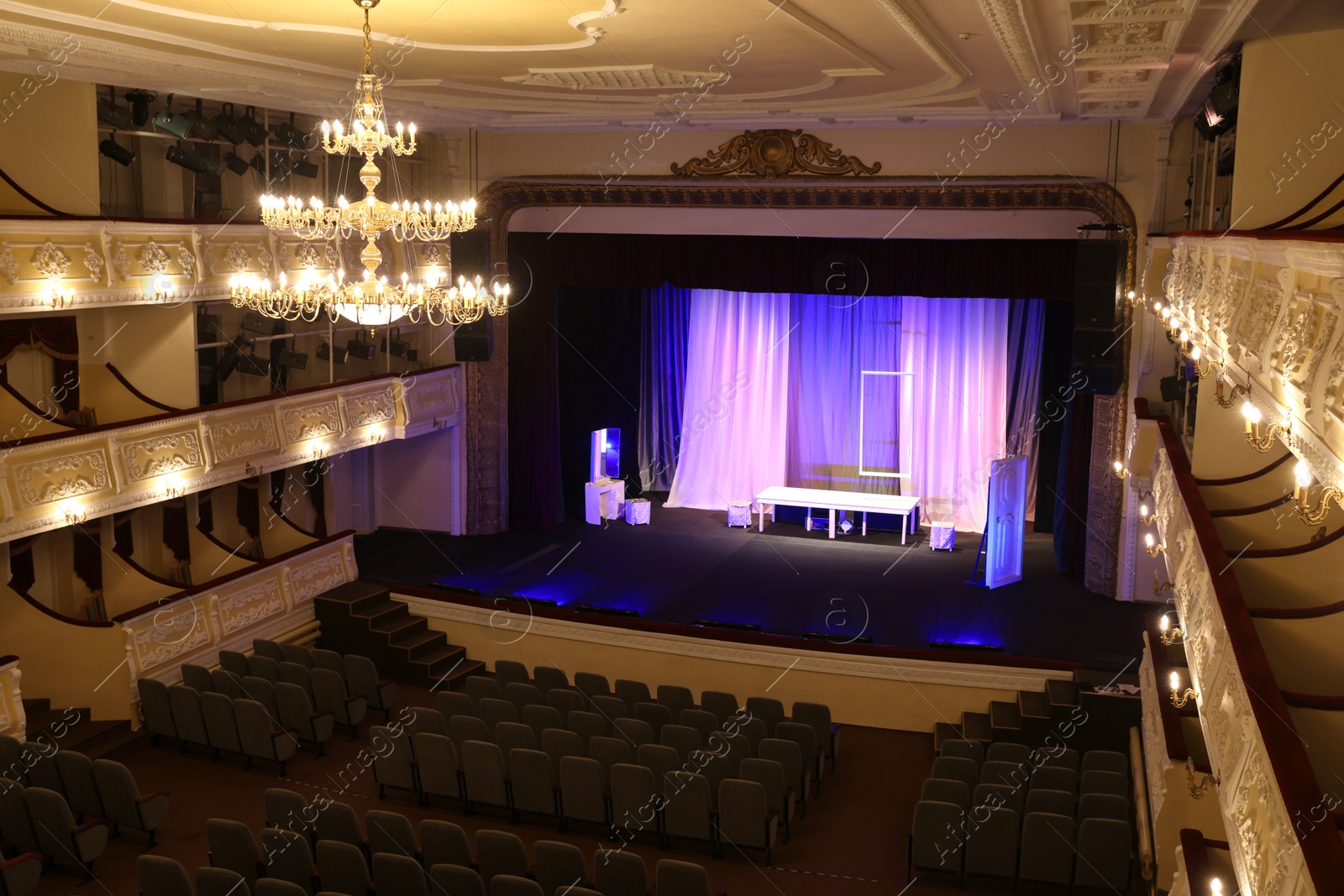 Photo of Theatre interior with stage, rows of comfortable seats and beautiful chandelier