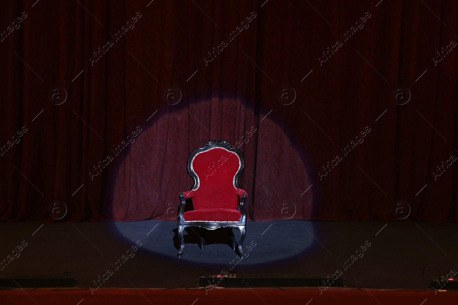 Photo of Vintage red armchair on stage in theatre