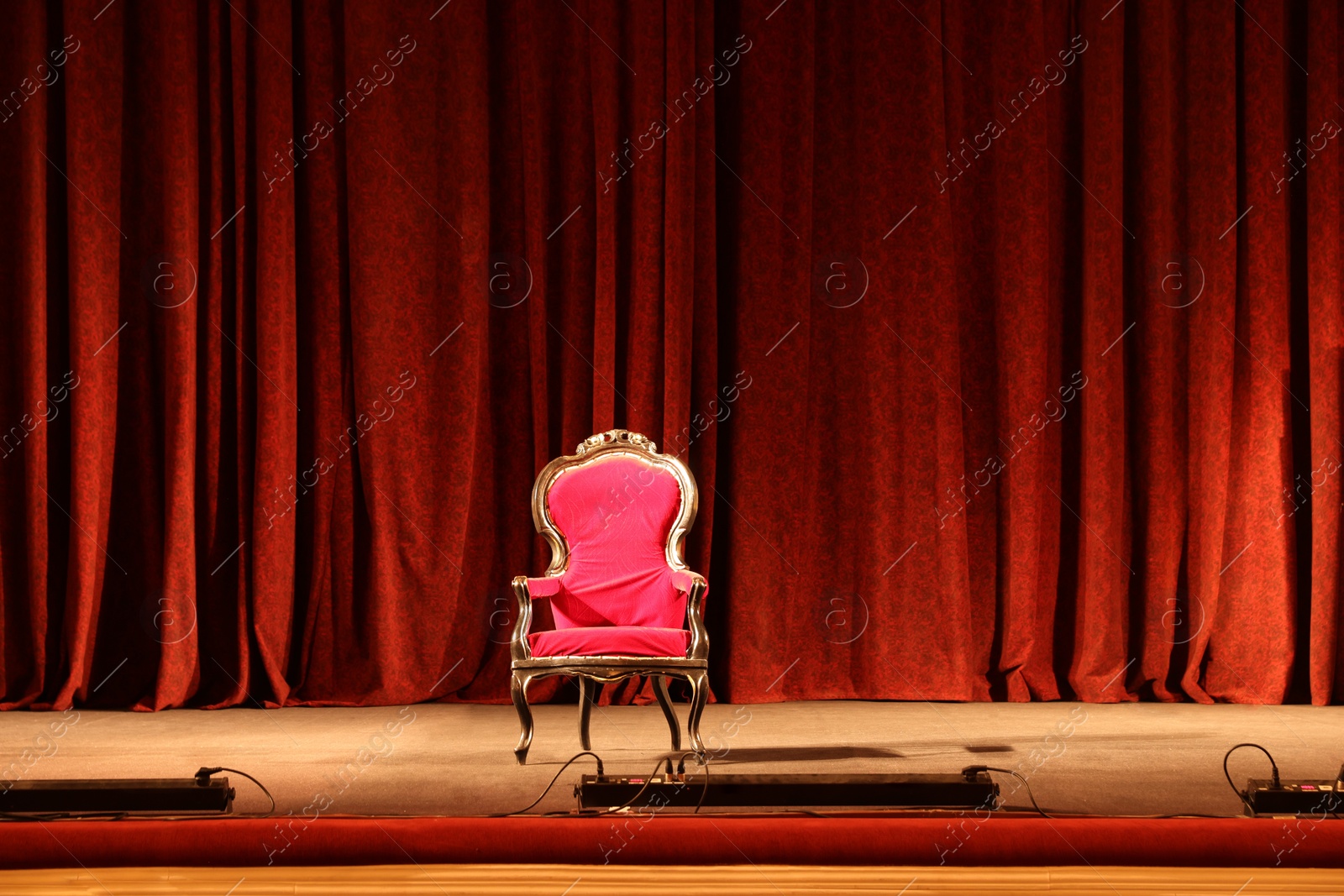 Photo of Vintage red armchair on stage in theatre