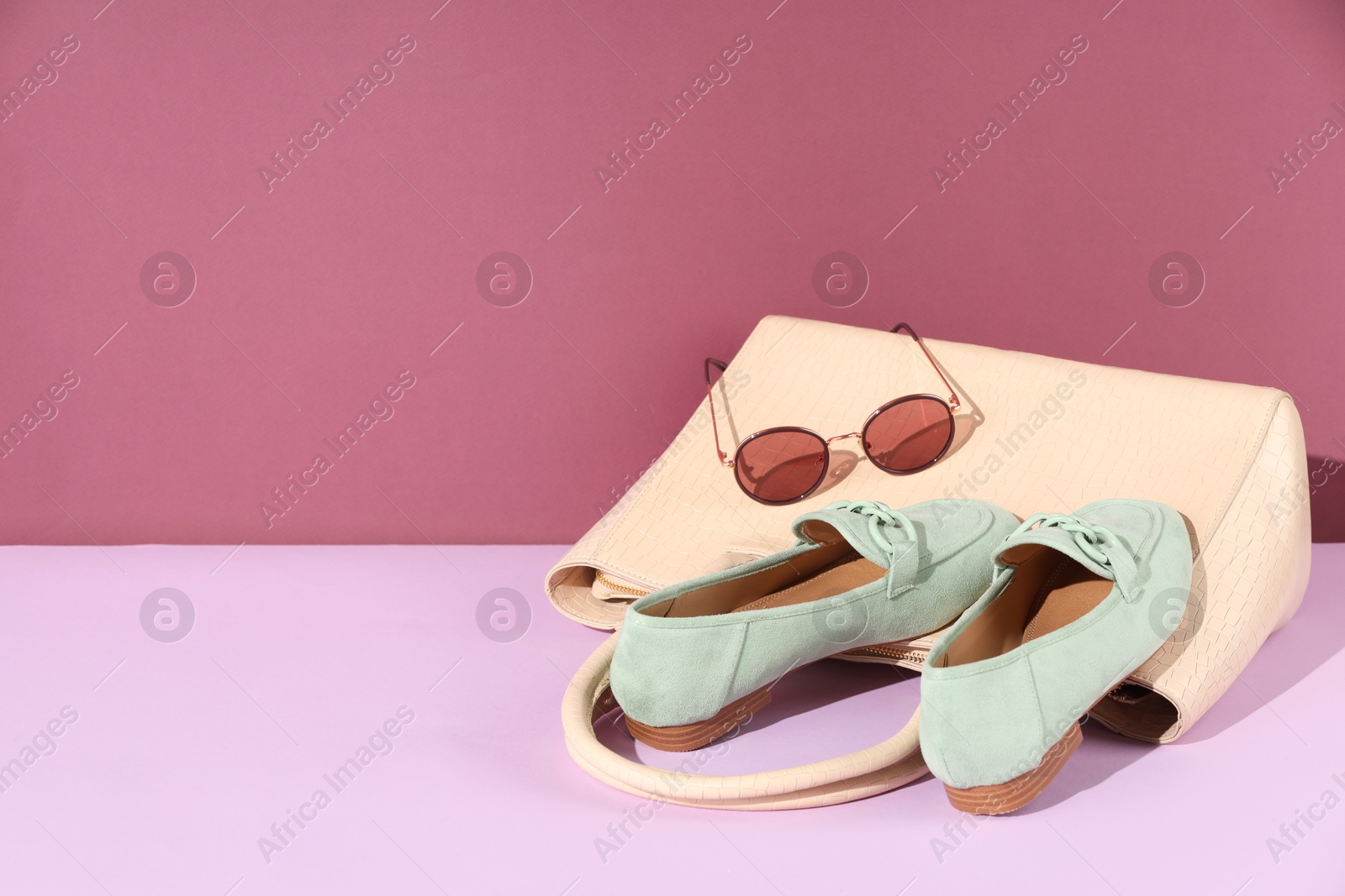 Photo of Shoes, bag and sunglasses on color background, space for text