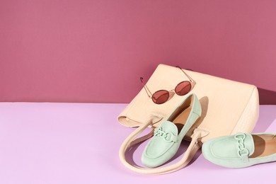 Photo of Shoes, bag and sunglasses on color background, space for text