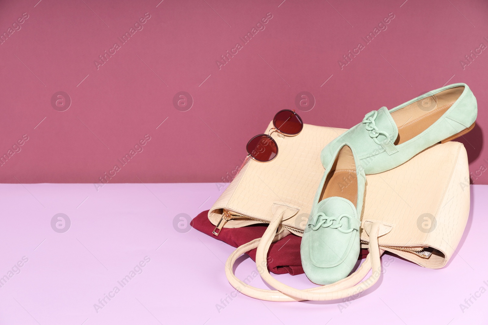 Photo of Clothes, shoes, bag and sunglasses on color background, space for text